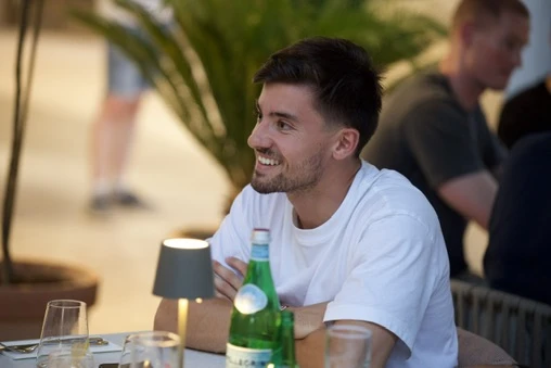Jérémy Vega, souriant, à une table en terrasse
